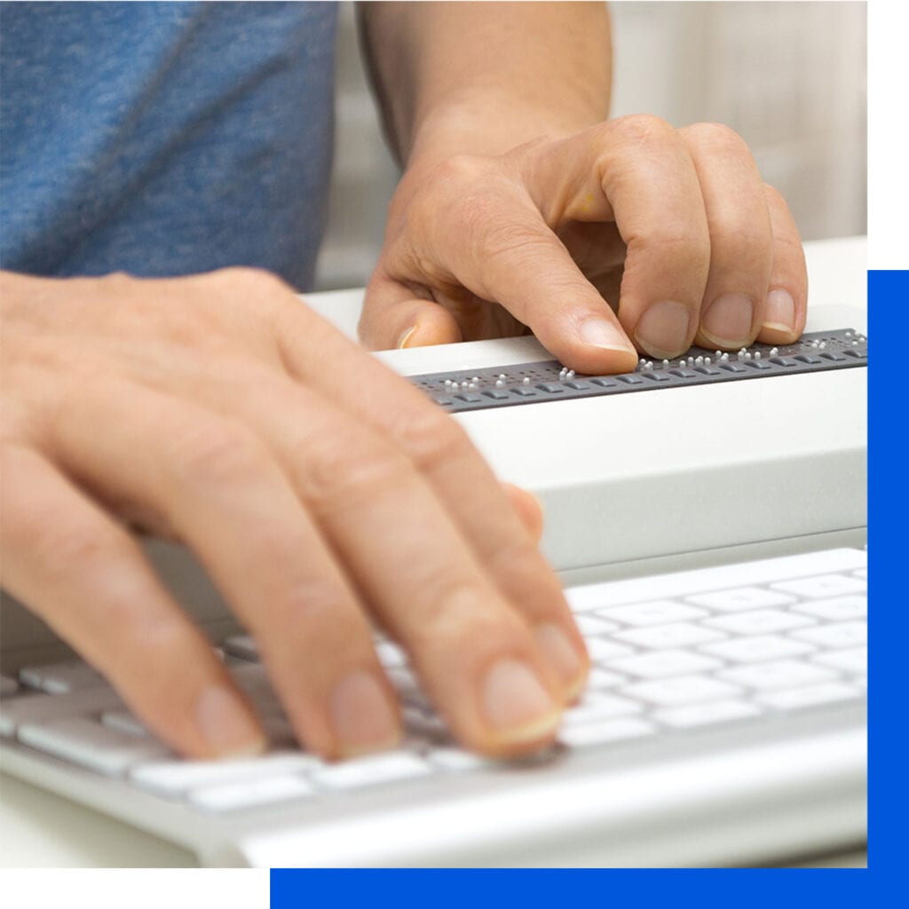 Blind person working on computer with braille keyboard