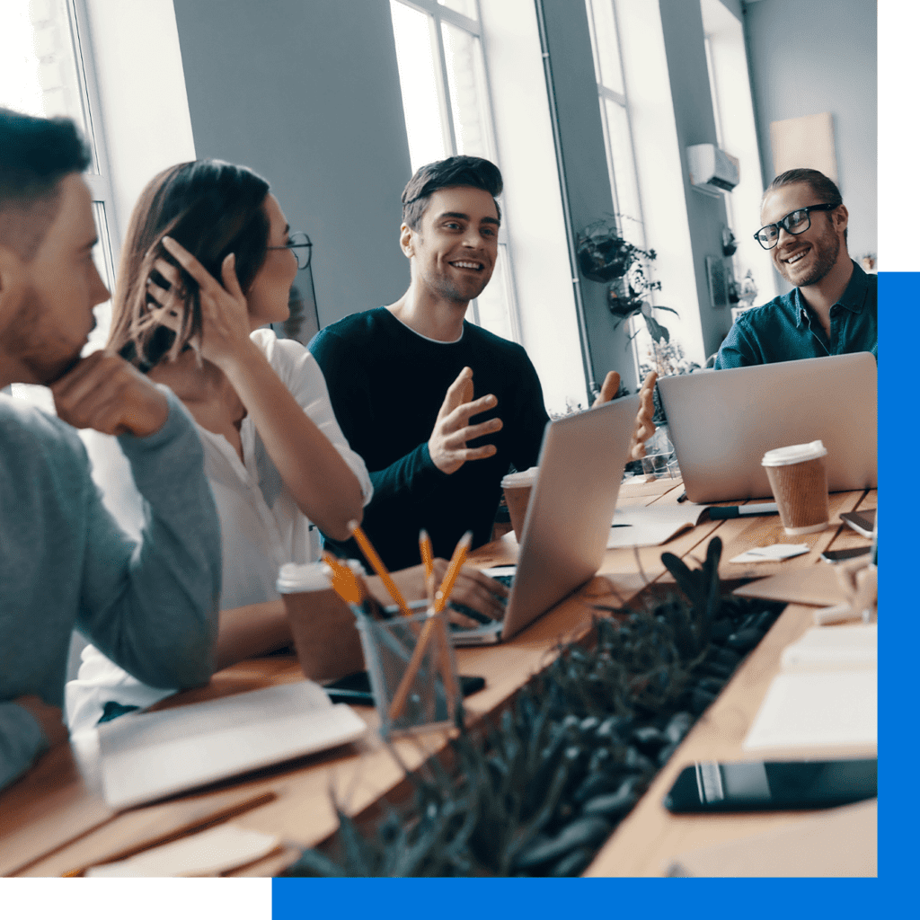 Group of young modern people discussing something and smiling while working in the creative office