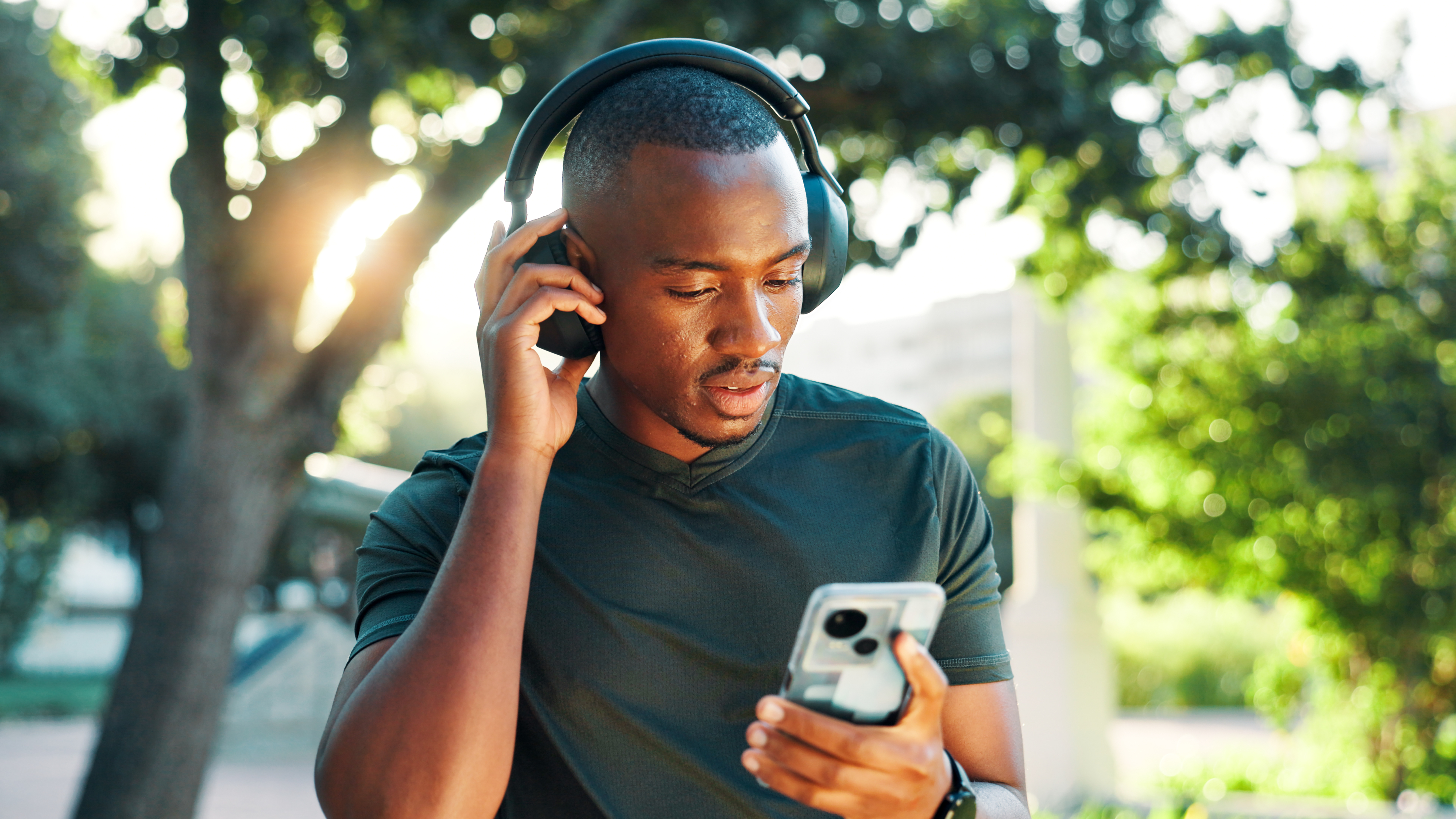 Image of a man listening to audio ads on his phone through headphones.